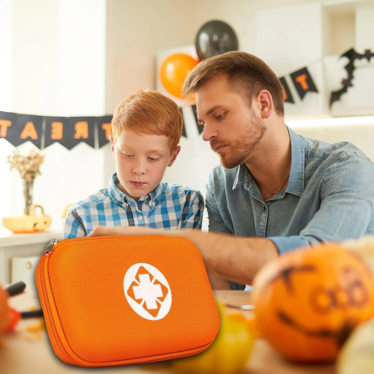 An adult and a child at a party table with an orange AMORNING first aid kit
