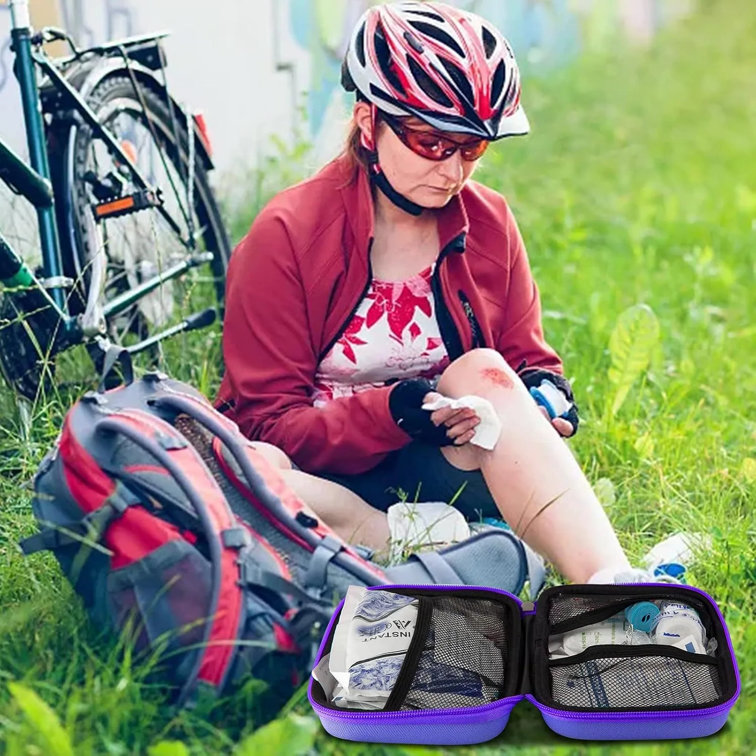 A cyclist sits in the grass with a scraped knee beside an open purple AMORNING kit